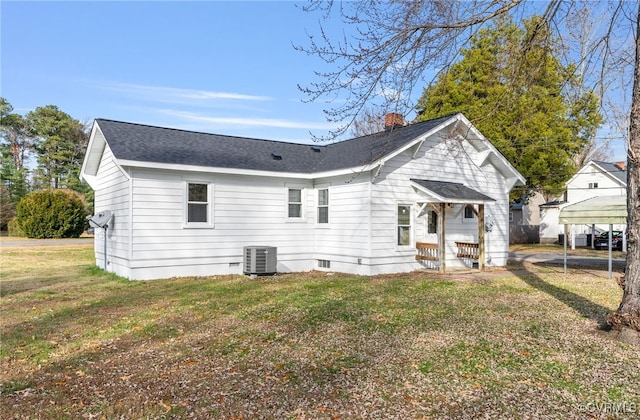 back of house featuring central air condition unit and a lawn