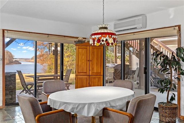 dining area with a wall mounted AC, plenty of natural light, and a water view