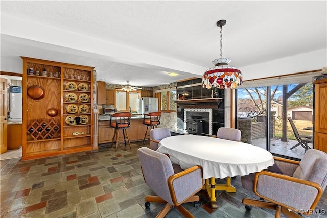 dining space featuring ceiling fan and a textured ceiling