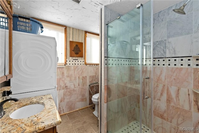 bathroom featuring vanity, toilet, an enclosed shower, and tile walls