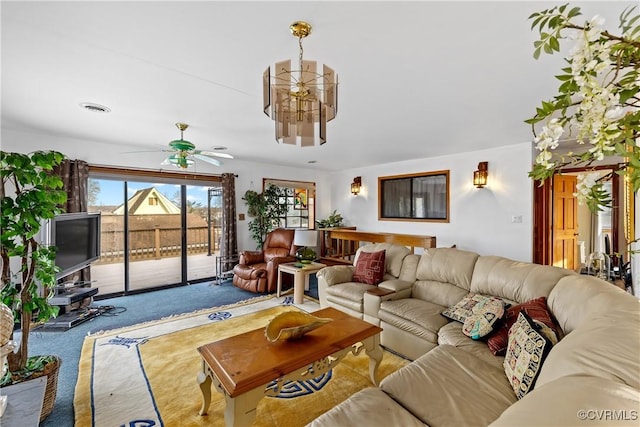 living room featuring ceiling fan with notable chandelier and light carpet