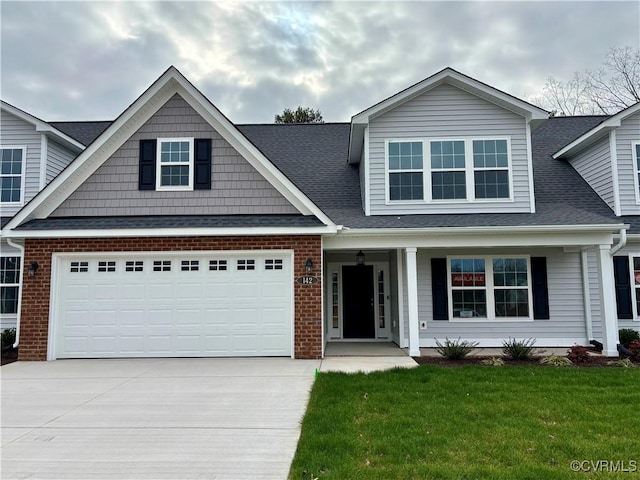 view of front facade with a porch, a garage, and a front yard