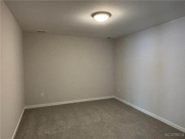 spare room featuring dark carpet