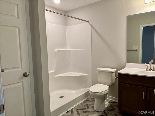 bathroom featuring vanity, toilet, and walk in shower