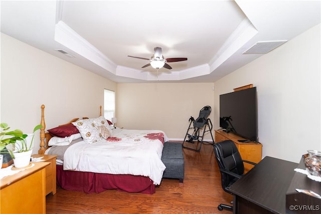 bedroom featuring a tray ceiling, ceiling fan, dark hardwood / wood-style flooring, and ornamental molding