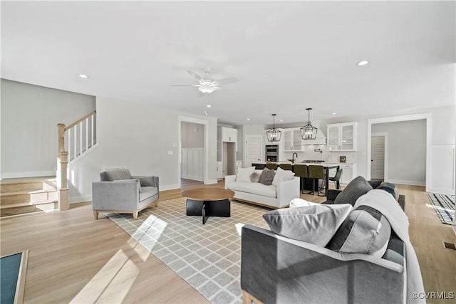 living room with ceiling fan, light hardwood / wood-style flooring, and sink