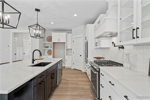 kitchen featuring white cabinetry, stainless steel appliances, a chandelier, decorative light fixtures, and light hardwood / wood-style floors