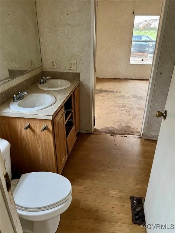 bathroom with hardwood / wood-style floors, vanity, and toilet