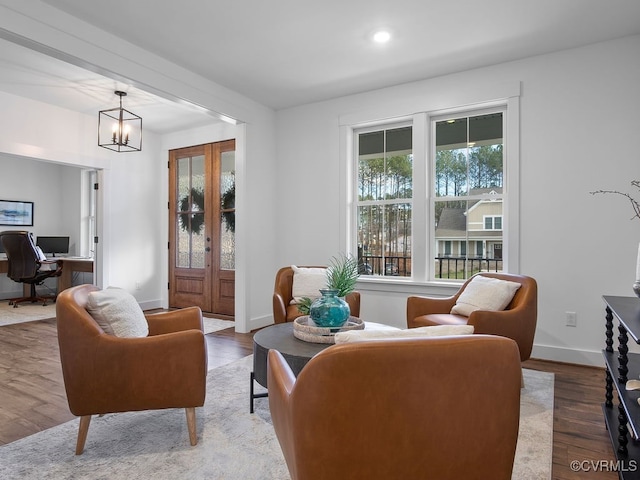 living area featuring a healthy amount of sunlight, baseboards, and wood finished floors