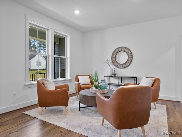 living area featuring recessed lighting, hardwood / wood-style flooring, and baseboards