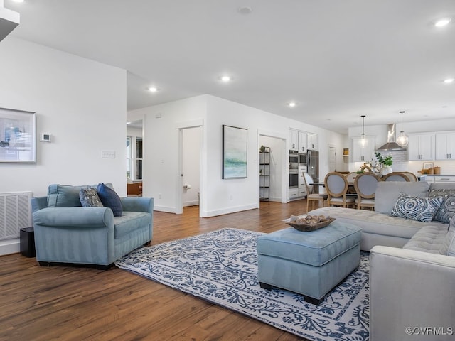 living room with dark wood-style floors, baseboards, visible vents, and recessed lighting