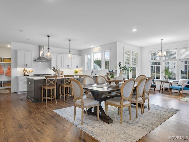 dining space featuring a notable chandelier, dark wood-style flooring, and recessed lighting