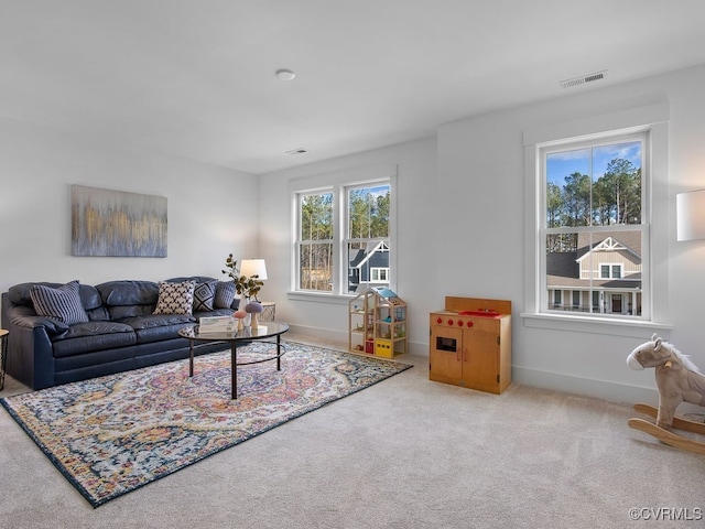 carpeted living room with visible vents and baseboards