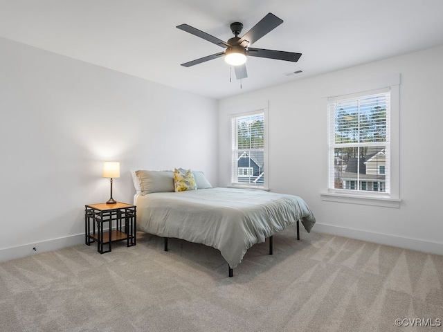 bedroom featuring carpet floors, baseboards, visible vents, and a ceiling fan