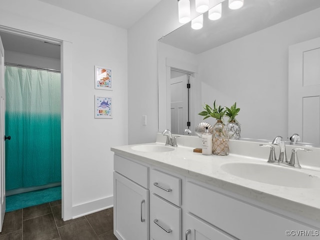 bathroom featuring tile patterned flooring, a sink, baseboards, and double vanity