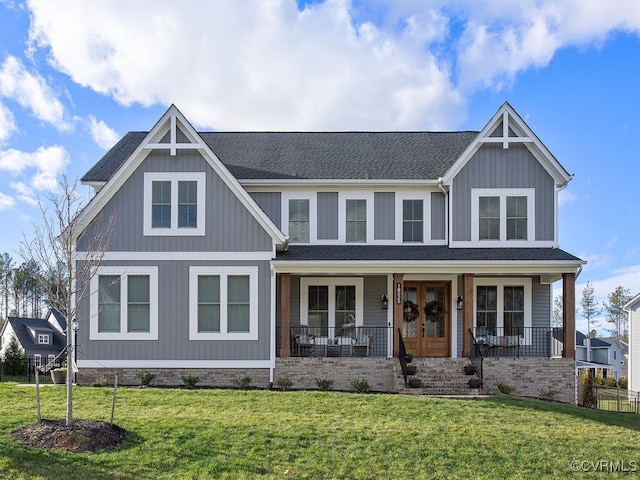 view of front of home featuring covered porch, a shingled roof, a front lawn, and french doors