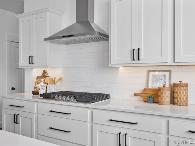 kitchen featuring light countertops, stainless steel gas cooktop, and wall chimney range hood