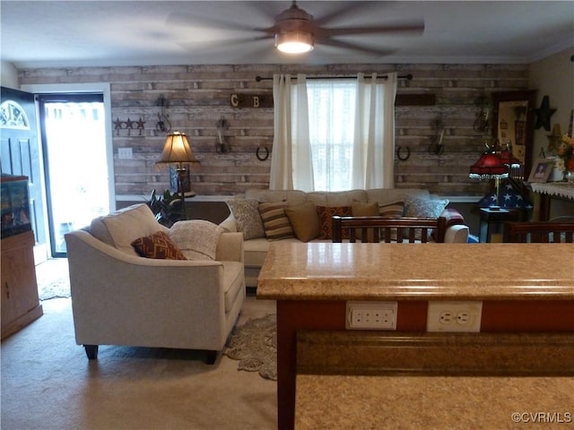 carpeted living room featuring crown molding and wooden walls