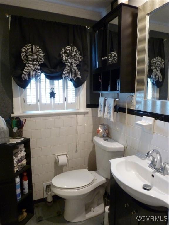 bathroom featuring vanity, toilet, and tile walls