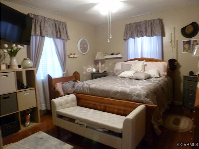 bedroom with dark hardwood / wood-style floors, ceiling fan, and multiple windows