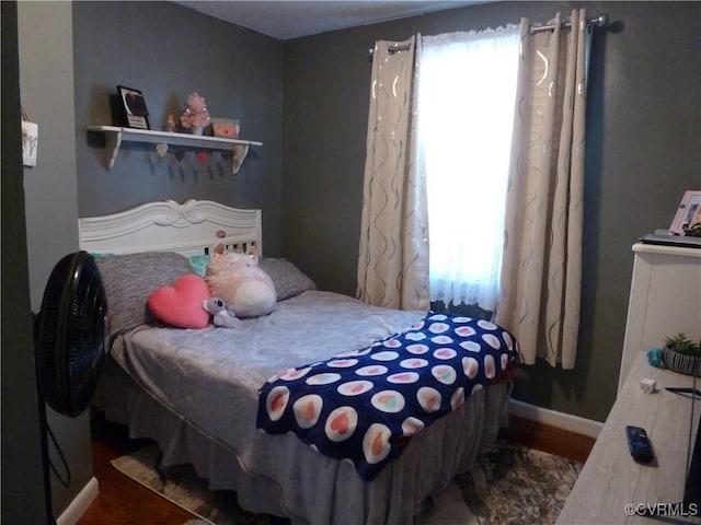 bedroom with dark hardwood / wood-style flooring and multiple windows