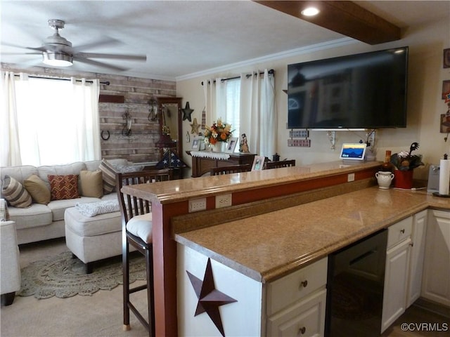 kitchen featuring white cabinets, ornamental molding, and a healthy amount of sunlight