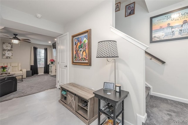 corridor with baseboards, stairway, and light colored carpet