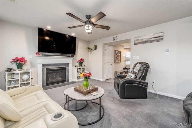 carpeted living room featuring a fireplace with flush hearth, ceiling fan, and baseboards