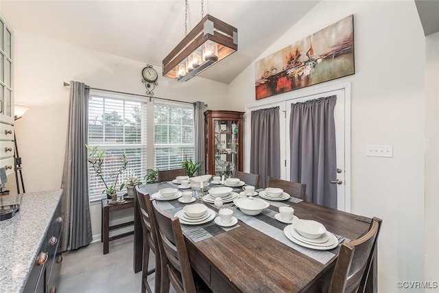 dining area featuring concrete floors and vaulted ceiling