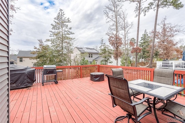 deck featuring outdoor dining space and a grill