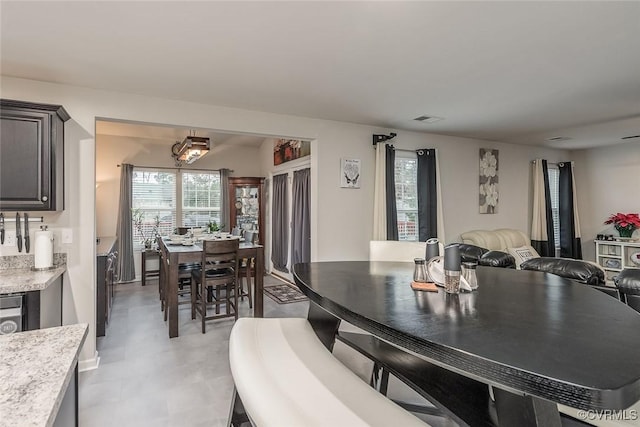 dining area featuring a healthy amount of sunlight, visible vents, and light floors