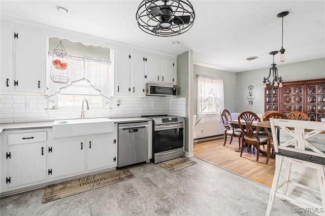 kitchen featuring ceiling fan, sink, stainless steel appliances, pendant lighting, and white cabinets