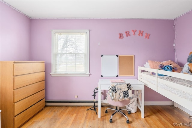 bedroom with light wood-type flooring and a baseboard heating unit