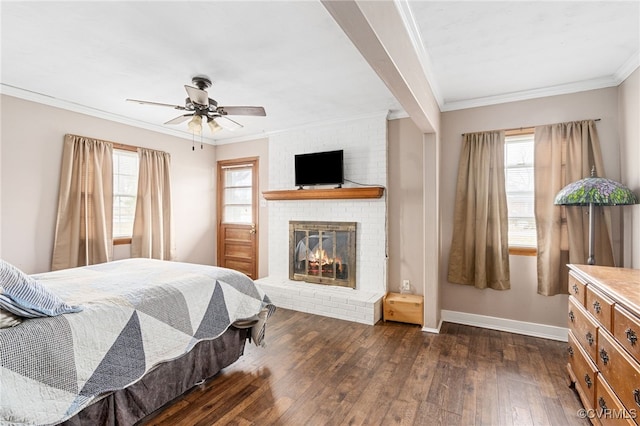 bedroom featuring dark hardwood / wood-style floors, ceiling fan, ornamental molding, and a fireplace