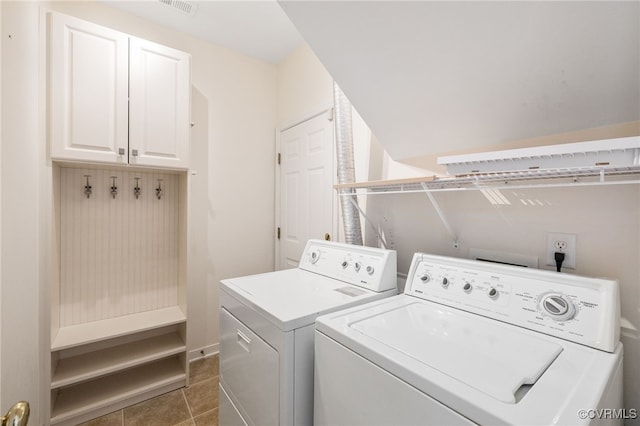 laundry area with cabinets, dark tile patterned flooring, and washer and clothes dryer