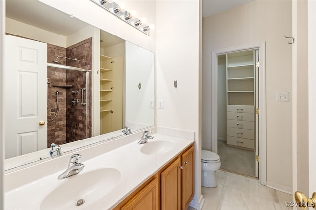 bathroom featuring vanity, toilet, and a shower with shower door