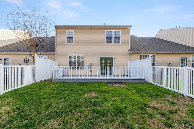 rear view of property featuring a deck and a lawn