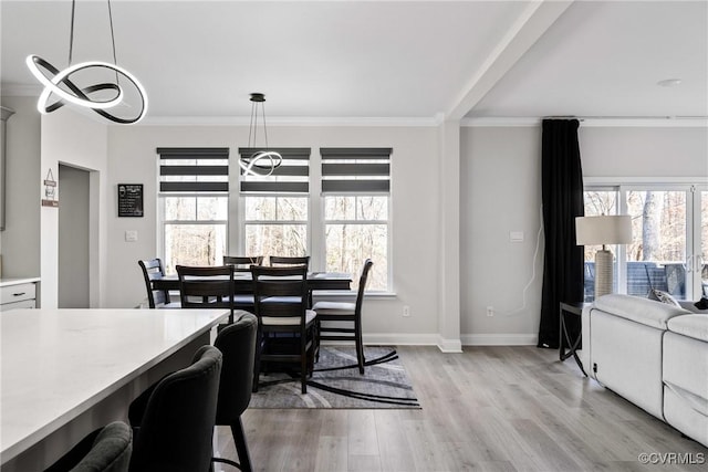 dining room with light hardwood / wood-style floors and ornamental molding