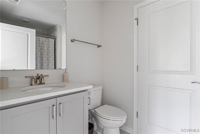 bathroom featuring vanity, toilet, and walk in shower