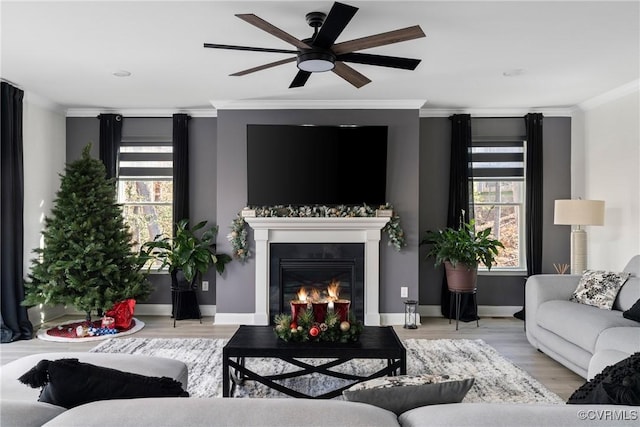 living room featuring a wealth of natural light, ceiling fan, light hardwood / wood-style floors, and ornamental molding