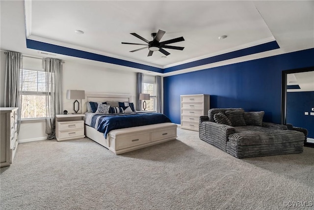 bedroom featuring light carpet, a raised ceiling, ceiling fan, and crown molding