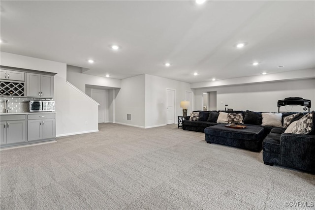 living room featuring light colored carpet and indoor wet bar