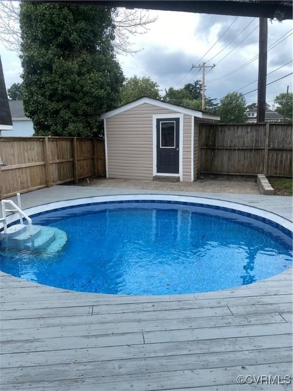 view of pool with a storage unit and a wooden deck