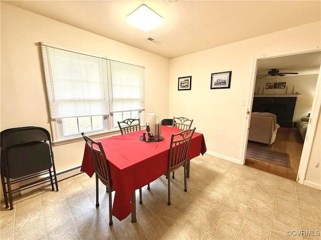 dining space with ceiling fan and a baseboard heating unit