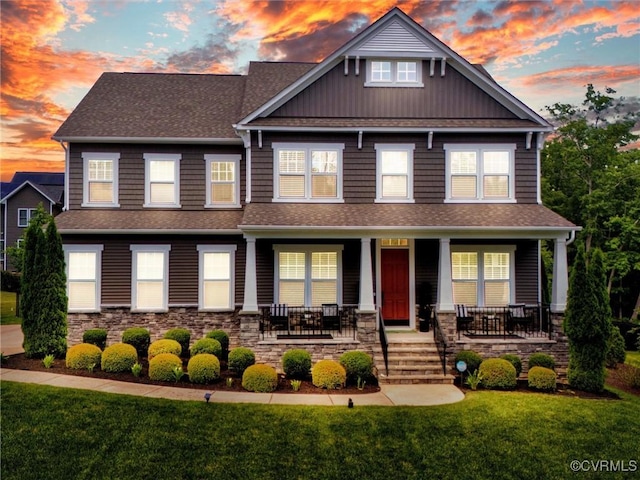 craftsman-style house featuring covered porch and a lawn