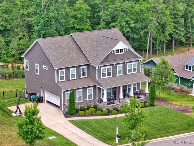 craftsman-style house featuring covered porch, a front yard, and a garage