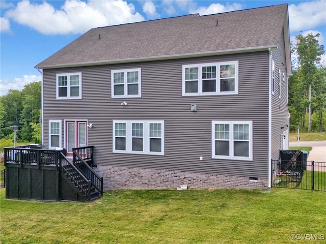 rear view of house with a lawn and a deck