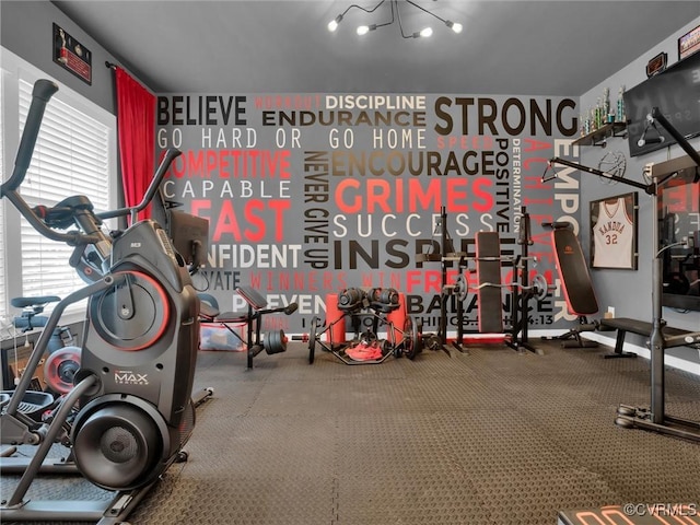 gym featuring an inviting chandelier