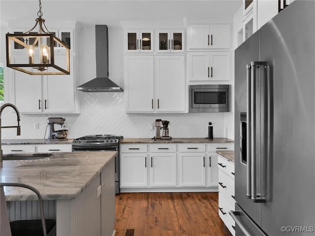 kitchen featuring white cabinets, hanging light fixtures, wall chimney exhaust hood, and stainless steel appliances