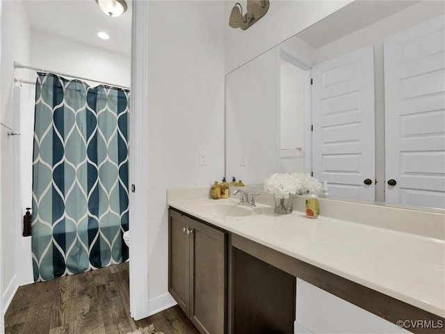 bathroom featuring vanity, hardwood / wood-style flooring, toilet, and walk in shower